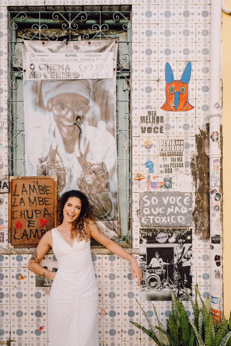 Tai posando em frente a um mural colorido e bem-humorado