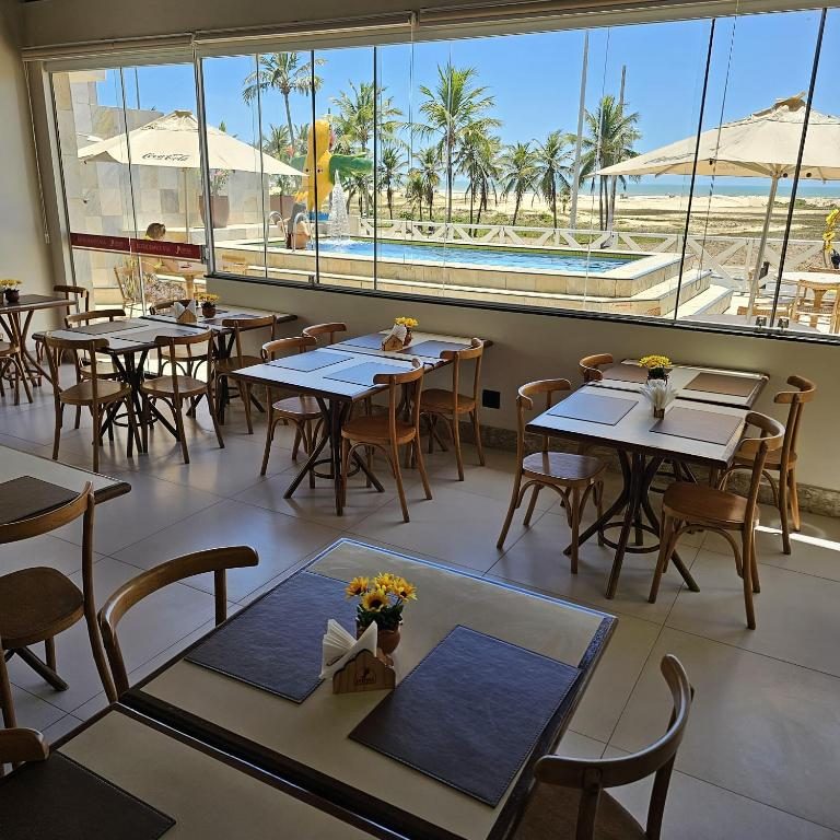 Área do café da manhã com vista para a piscina e o mar